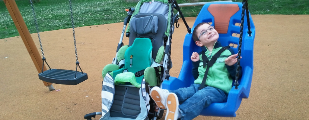 Schaukelndes Kind in einem Spezialsitz